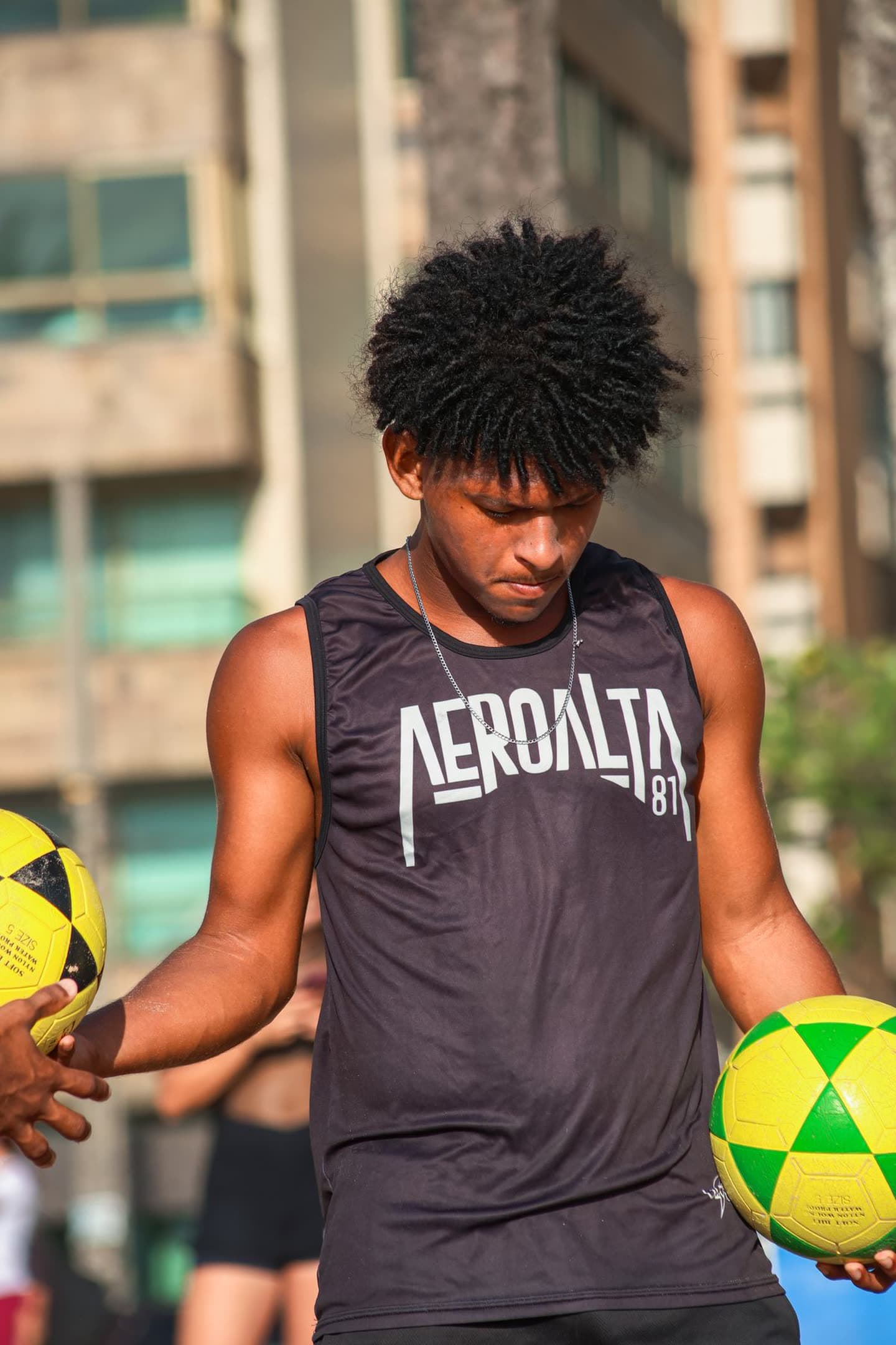 Atleta de regata do Aero Alta 81 segurando duas bolas de altinha, em Boa Viagem